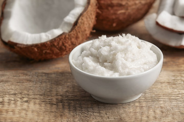 Fresh coconut oil in bowl on wooden background