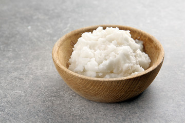 Wooden bowl with fresh coconut oil on table