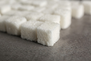 Rows of sugar cubes on gray background