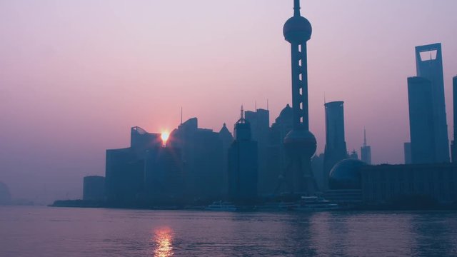 Sun in showing from behind the building in Shanghai central business district. No ships. 4K UHD