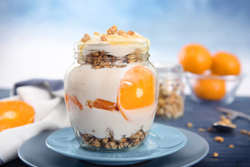 Tasty yogurt with granola on wooden table