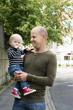 Sweden, Portrait of father with baby son (12-17 months) in city street
