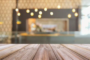Empty wooden table top with blurred coffee shop interior background.