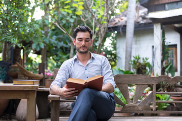 Young relaxed man reading book in nature

