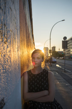 Germany, Berlin, Portrait of young woman leaning against wall