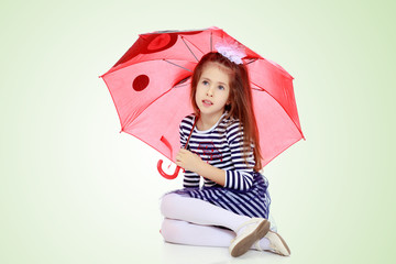 Little girl hiding under an umbrella.