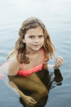 Sweden, Vastmanland, Hallefors, Bergslagen, Portrait of smiling girl ( 8-9) in lake