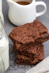 Brownie and milkman with caramel on gray background close-up.
