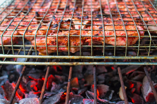 Grilled pork ribs on fireplace closeup photo. Red meat barbecue cooking.