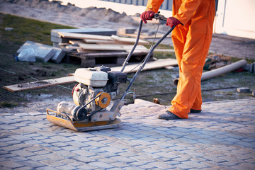 Work vibroinstrumentom for the construction of the sidewalk.