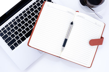 Modern White office desk table with laptop computer, blank page notebook and office gadgets. Top view with copy space.