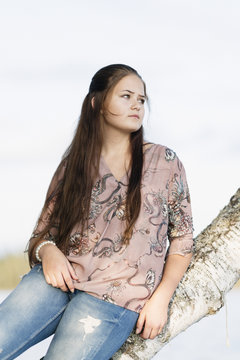 Sweden, Vastmanland, Hallefors, Bergslagen, Portrait of girl (12-13) sitting on tree