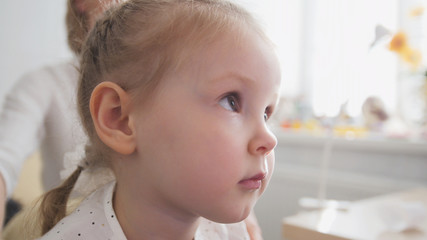 Portrait of little adorable blonde girl in child's ophthalmology clinic