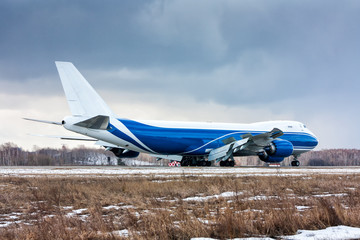 Big cargo plane moves on the runway at a cold winter airport