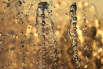 drops of the fountain in the setting sun.