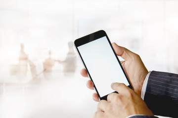 Businessman using smartphone in meeting room. Blank screen smartphone for Graphic montage.