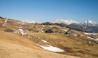 Scenic high alpine pasture Velika Planina and old wooden traditional shepherd cottages during spring time near Kamnik in Slovenia