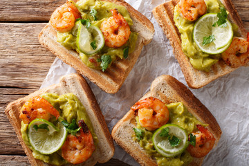 tasty Mexican sandwiches with guacamole, prawns and lime close-up. horizontal top view
