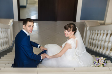 Obraz na płótnie Canvas Wedding couple on hotel stairs, in interior