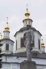 Fototapeta na wymiar Monument to Semyon Ivanovich Dezhnev against the background of the domes of the Cathedral of the Assumption of the Blessed Virgin Mary in Veliky Ustyug, Vologda region, Russia