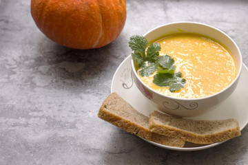 A bowl of French pumpkin soup with bread