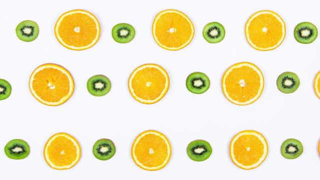 Traffic From Fruits. Sliced Fruit Moves in Different Directions. Stop Motion Animation With Oranges and Kiwi on a White Background. Top View. 4K.