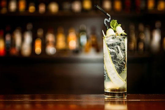 Cocktail with cucumber on a bar counter in a night club