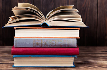 Many old books on wooden background. The source of information. Open book indoor. Home library. Knowledge is power