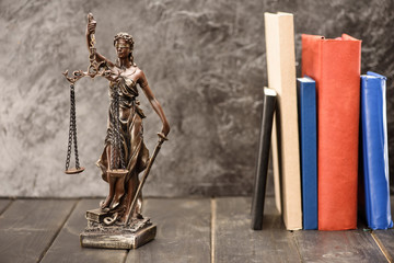 Close-up view of antique statue of lady justice and books, Law concept