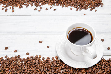Mug of black coffee on white wooden background.