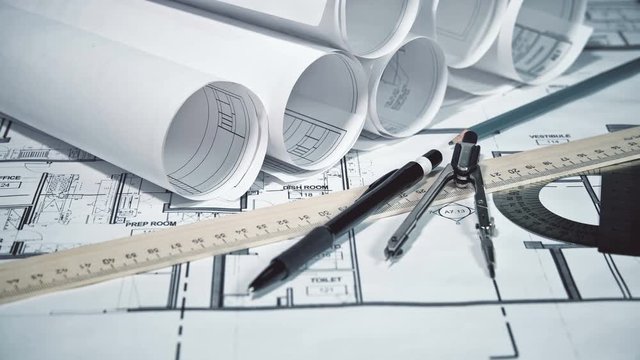 Engineer's desk with drawings, helmet, ruler, pencil