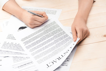 Obraz premium cropped view of businesswoman signing contract documents sitting at table