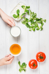 Woman's hand holding a mug of tea and yogurt. Comparison of tea and yogurt.