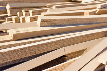 Pile of discarded chipboard parts or planks.