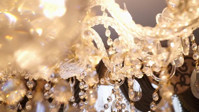 Crystal chandelier. Big classic crystals. Low angle shot of a big beautiful crystal luxury chandelier. With bling bling shining reflection.