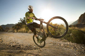 Fototapeta na wymiar Cyclist man riding mountain bike at sunset