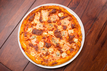 Four cheese pizza top view with wooden table