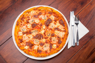 Four cheese pizza top view with wooden table