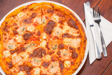 Four cheese pizza top view with wooden table