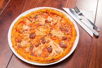 Salmon pizza on a wooden table