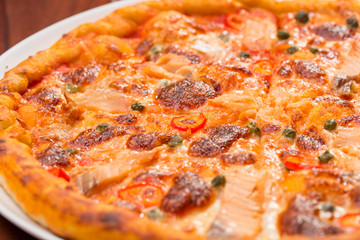 Salmon pizza on a wooden table