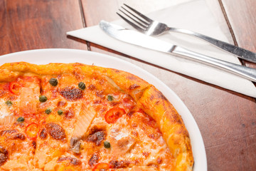 Salmon pizza on a wooden table