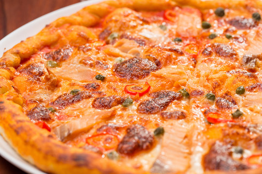 Salmon pizza on a wooden table