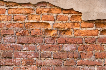 Old brick wall with piece of cement