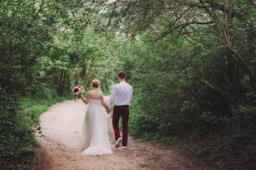Fototapeta premium Young beautiful wedding couple hugging on nature. Lovely couple, bride and groom posing, lifestyle