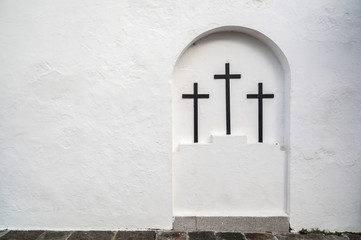 Tree crosses in white niche wall.