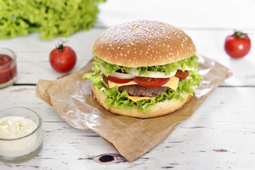 Fresh, delicious burger or cheeseburger with sauces and fresh ingredients. Hamburger on a white table.