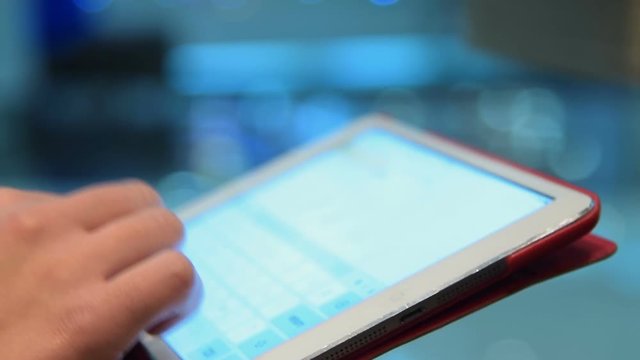 Close-up shot of a woman typing email on tablet computer