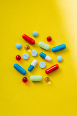 colorful pills and drugs in close up.assorted pills and capsules in medicine. drugs of various kinds and different colors. Medicine on yellow background