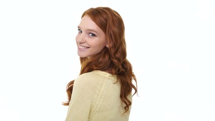 Happy young smiling woman with red curly hair blowing air kiss and waving her hand as goodbye over white